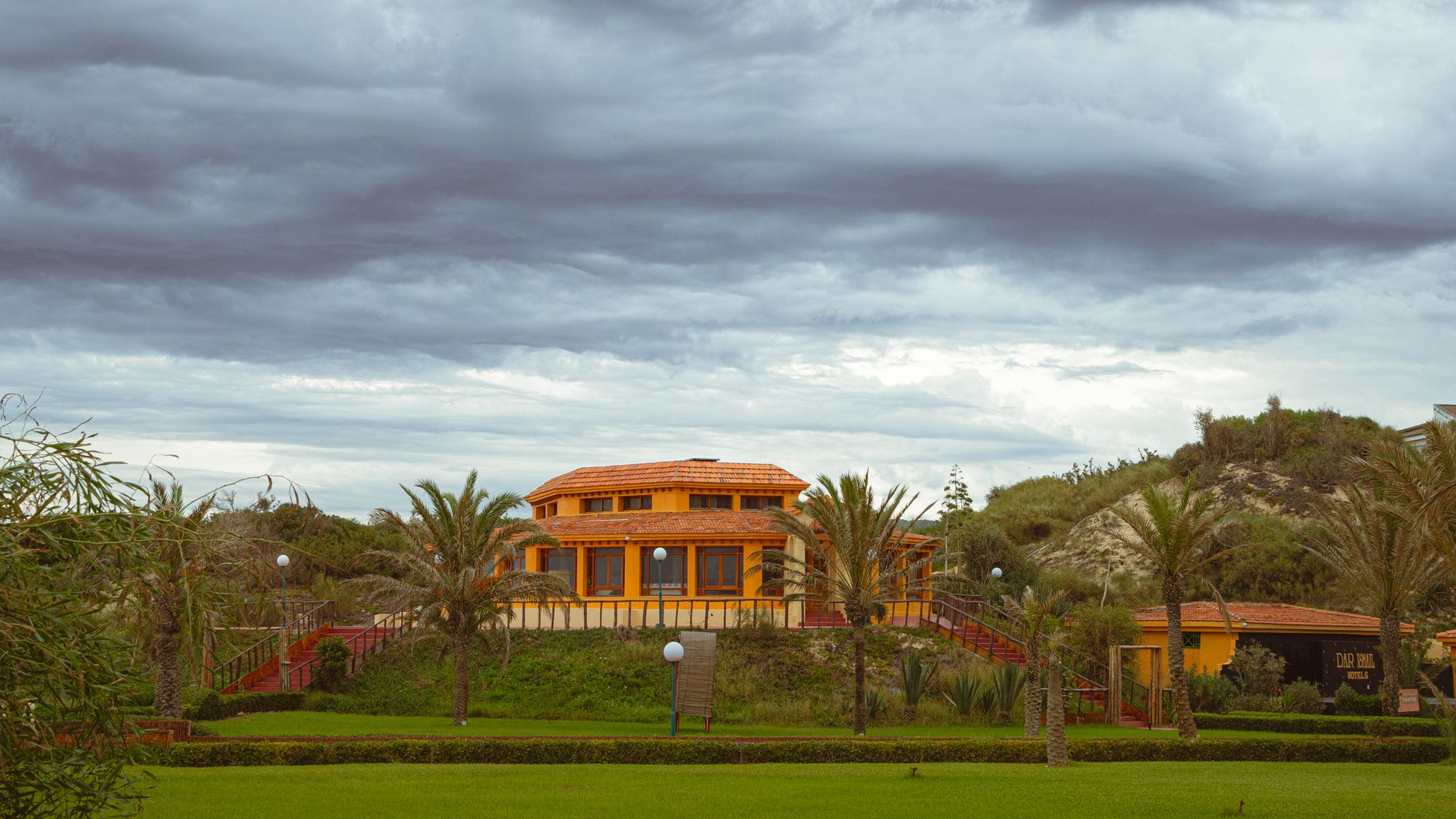 A rustic villa surrounded by lush greenery under cloudy skies in Tabarka, Tunisia.