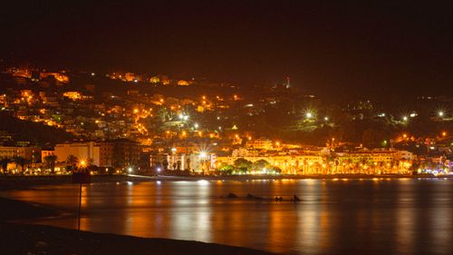 Free Scenic night view of Tabarka city lights reflecting on the calm sea, in Tunisia. Stock Photo