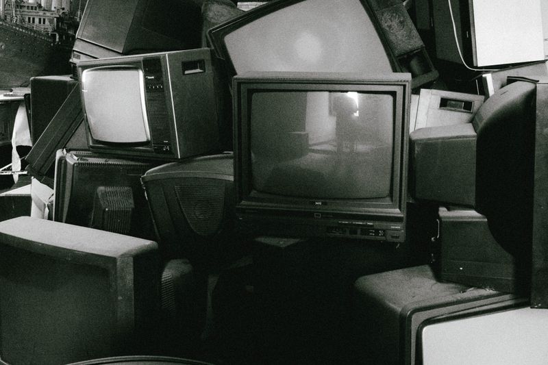 A stack of retro televisions evokes nostalgia and past technology in black and white.