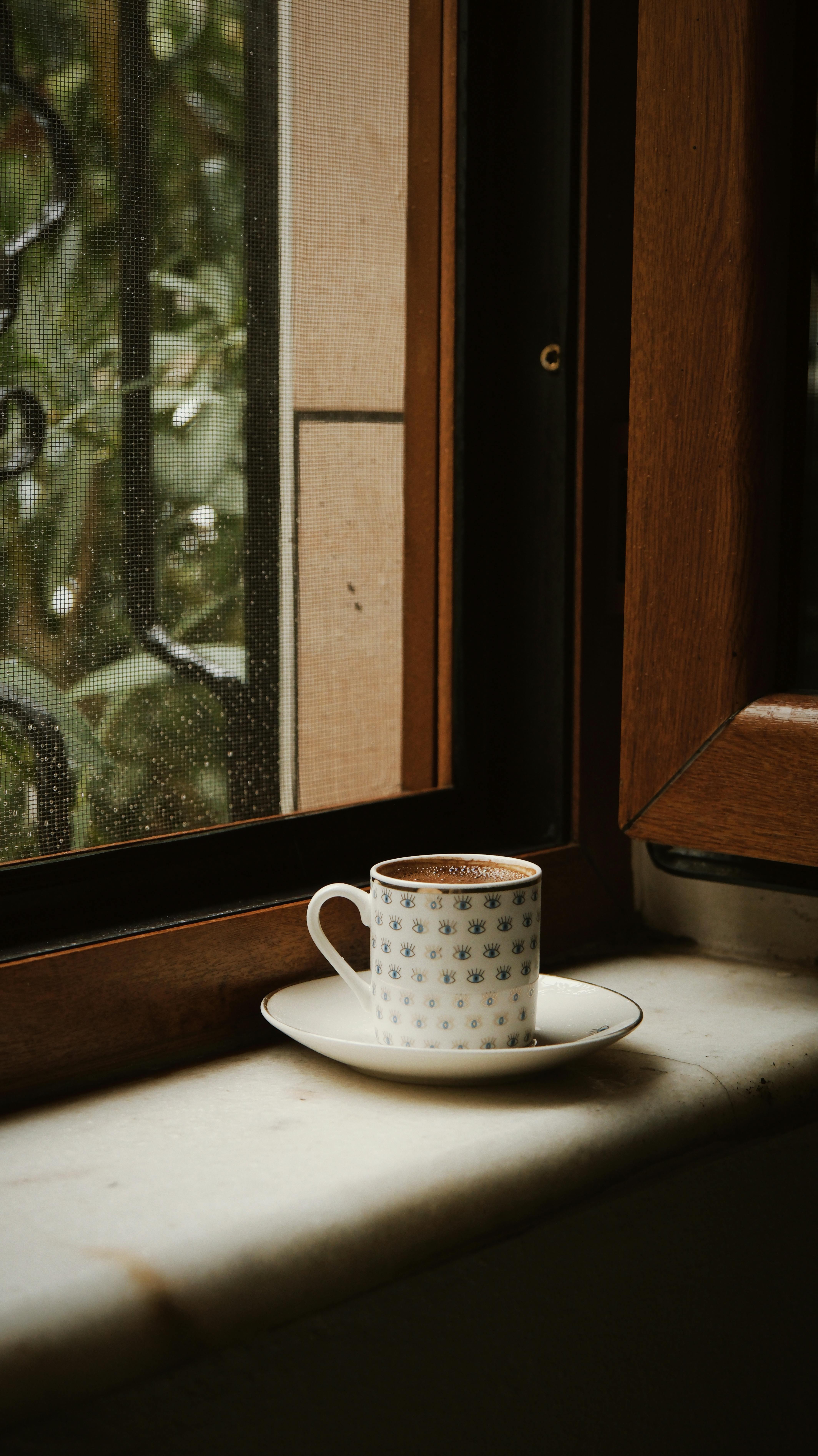 A charming coffee cup on a windowsill during a rainy day in Bursa.