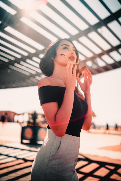 Mujer Sosteniendo Gafas De Sol