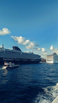 Cruise ships in open sea under a clear blue sky, perfect for travel enthusiasts.