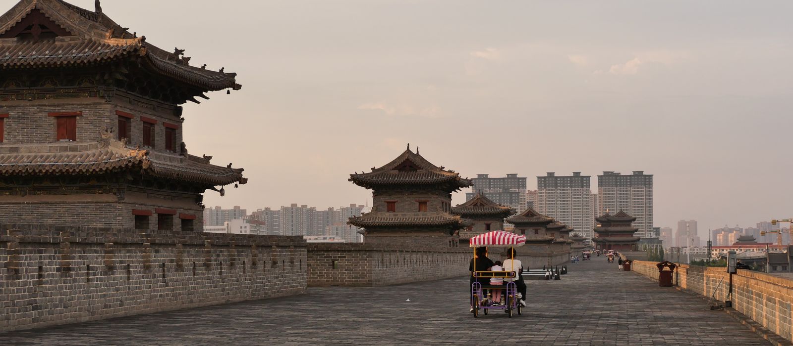 Cyclists enjoy a ride along the historic Xi'an City Wall at sunset. — flights from Tianjin to Xian