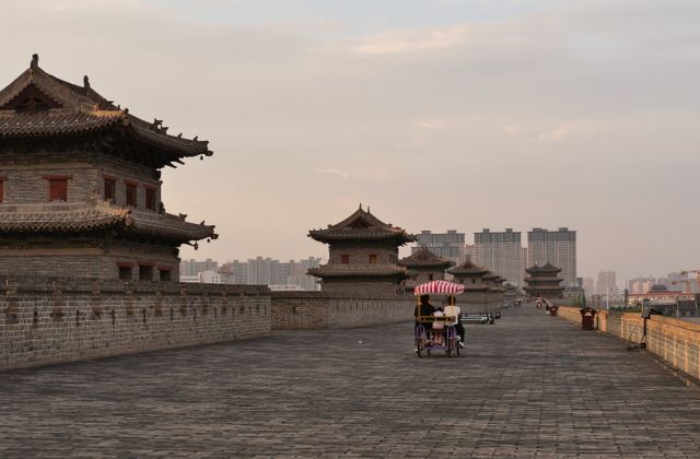 Cyclists enjoy a ride along the historic Xi'an City Wall at sunset. — arriving in Xi'an