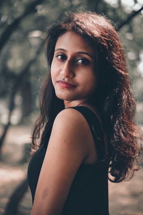 Free A serene portrait of a young woman captured outdoors with soft natural light. Stock Photo
