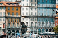 阳光明媚的日子里，游客们漫步在波尔图里贝拉区色彩缤纷的建筑物下