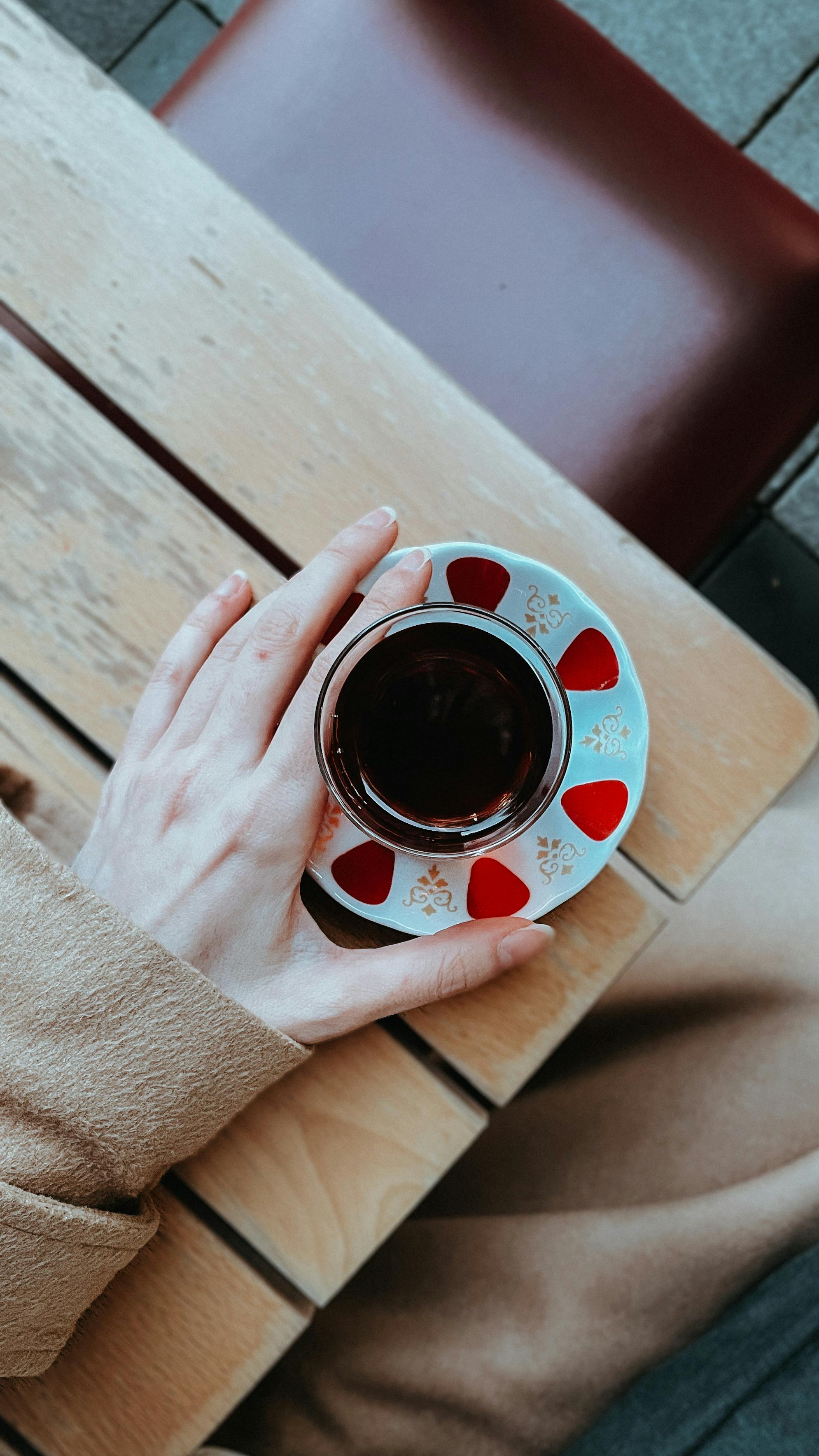 overhead view of person holding coffee cup outdoors