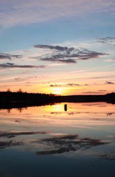 Tranquil sunset over a serene lake in Berlin, captured with vibrant reflections.