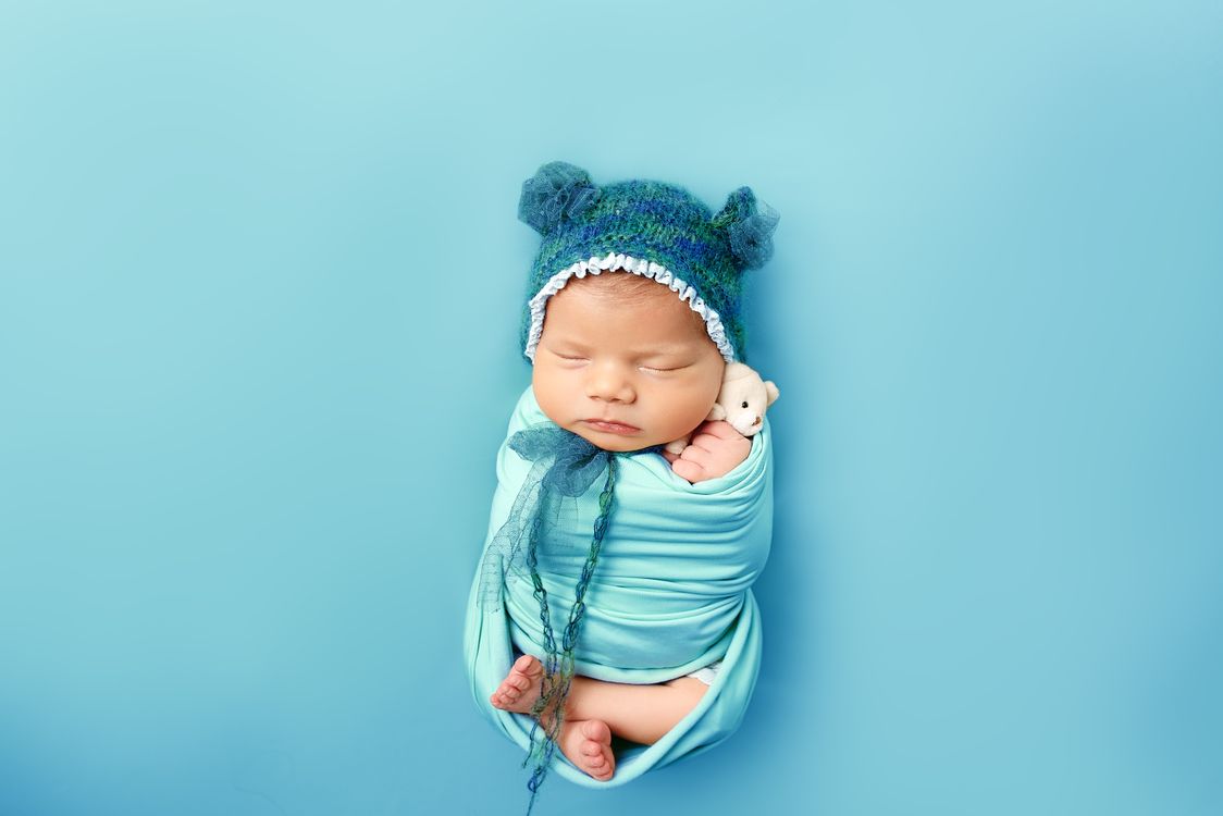 Sleepy Newborn in Blue with Teddy Bear Hat · Free Stock Photo