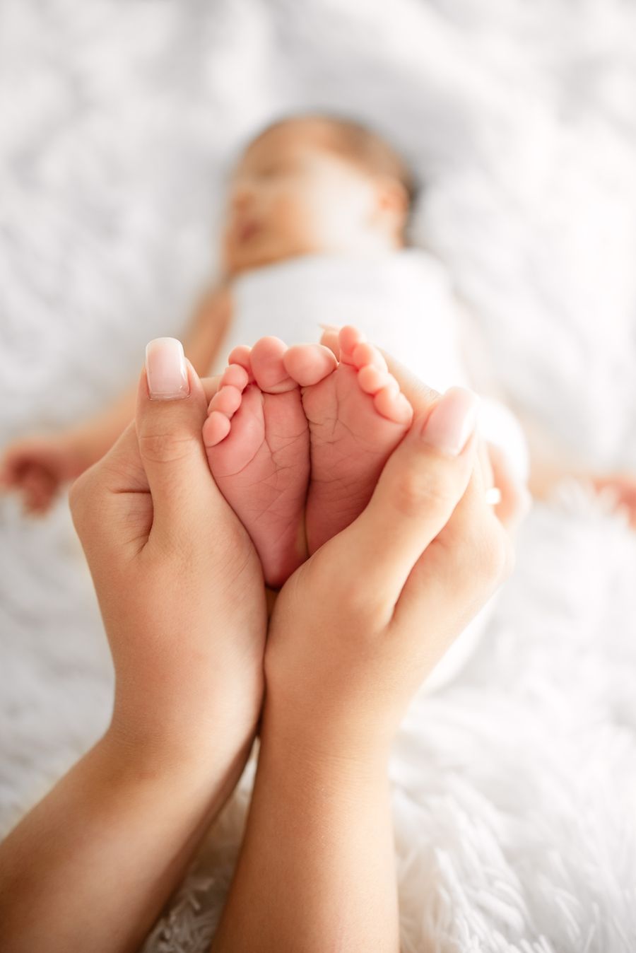 Pieds d’un nouveau-né tenus avec tendresse par un parent