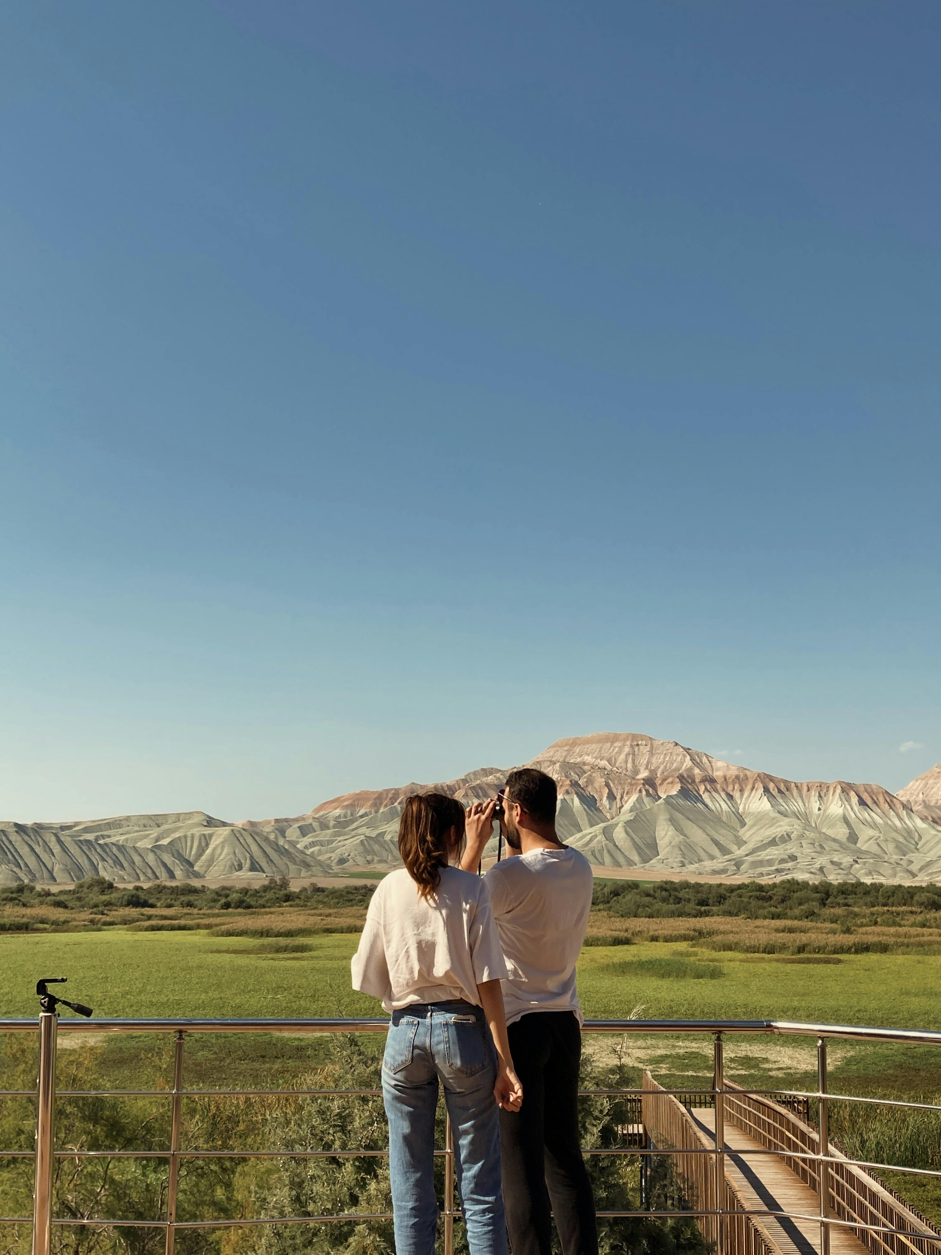 Couple enjoying a breathtaking mountain view outdoors during the day.