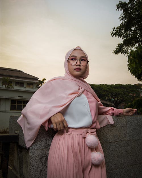 Free Photo of Muslim Woman in Pink Hijab Posing By Stone Wall Stock Photo