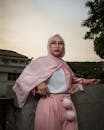 印度尼西亚万隆黄昏时，穿着粉红色头巾的时尚穆斯林妇女在石墙前摆姿势