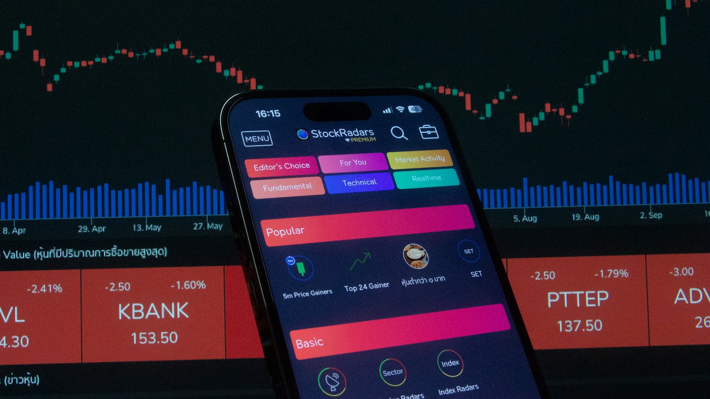 Smartphone che mostra interfaccia di trading con grafici e indicatori
