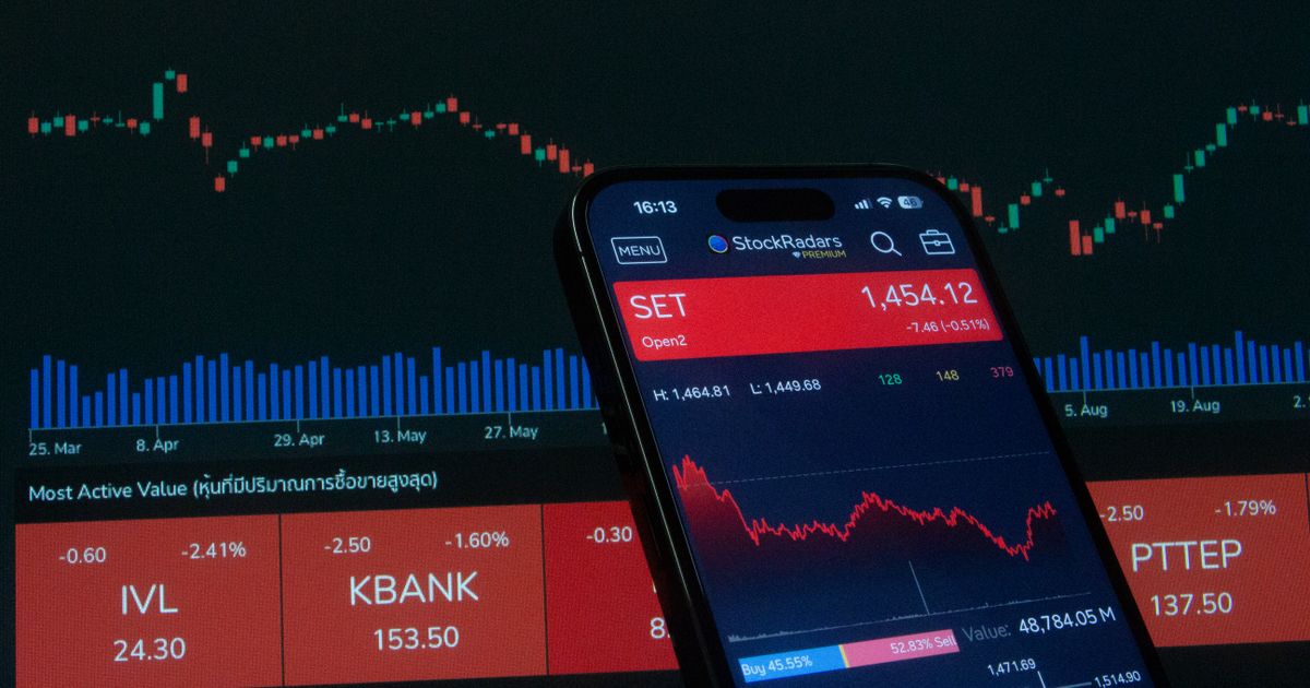Mobile app showing stock market data with charts on screen.