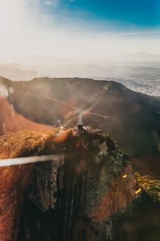 Stunning aerial view of Christ the Redeemer in Rio de Janeiro at sunrise, showcasing vibrant sunrays and breathtaking landscape.
