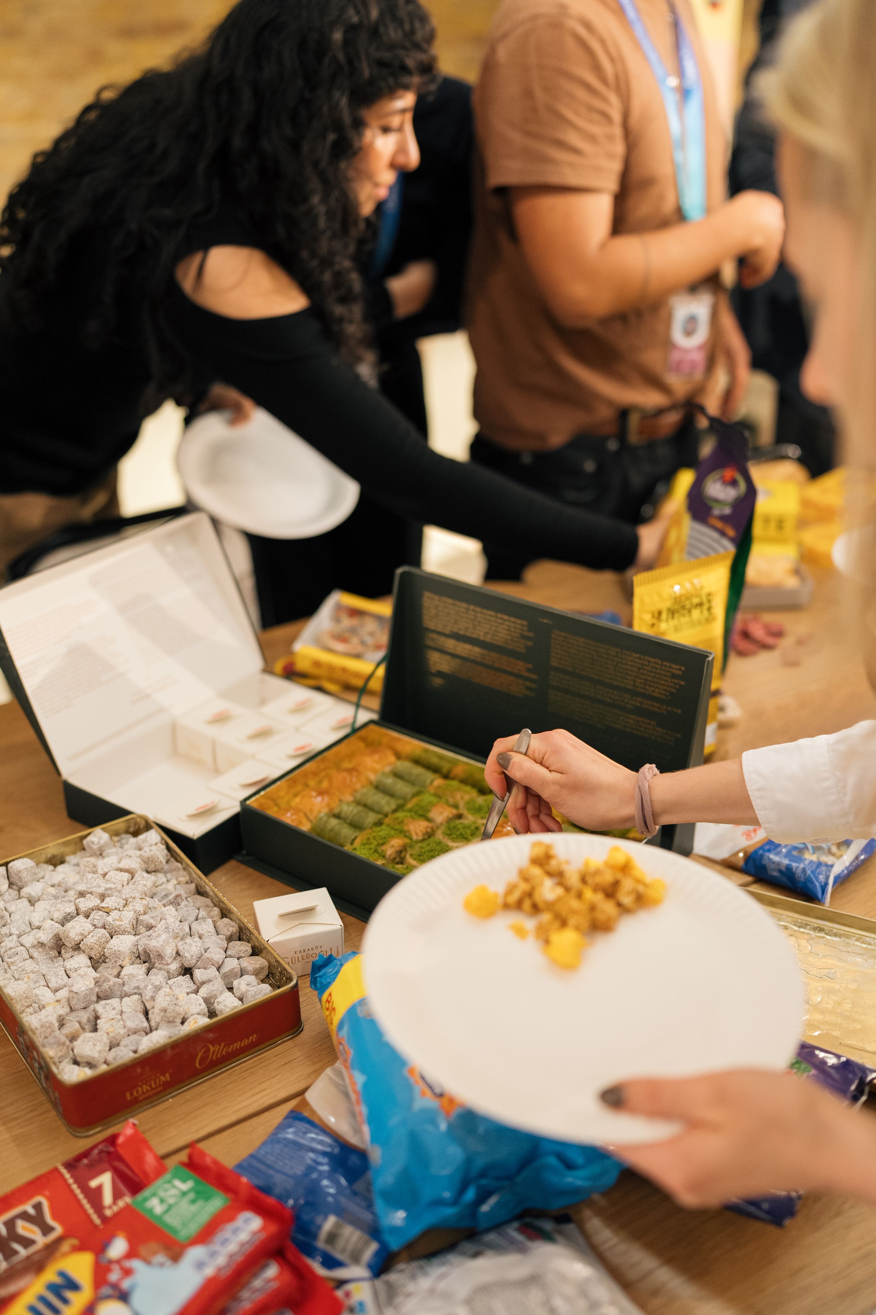 People enjoying a variety of snacks during a social gathering in London, UK.