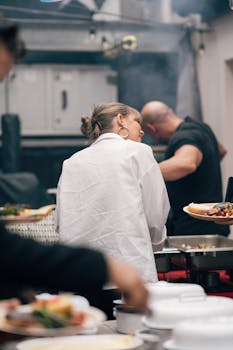 Two people preparing food at an outdoor buffet event in London.