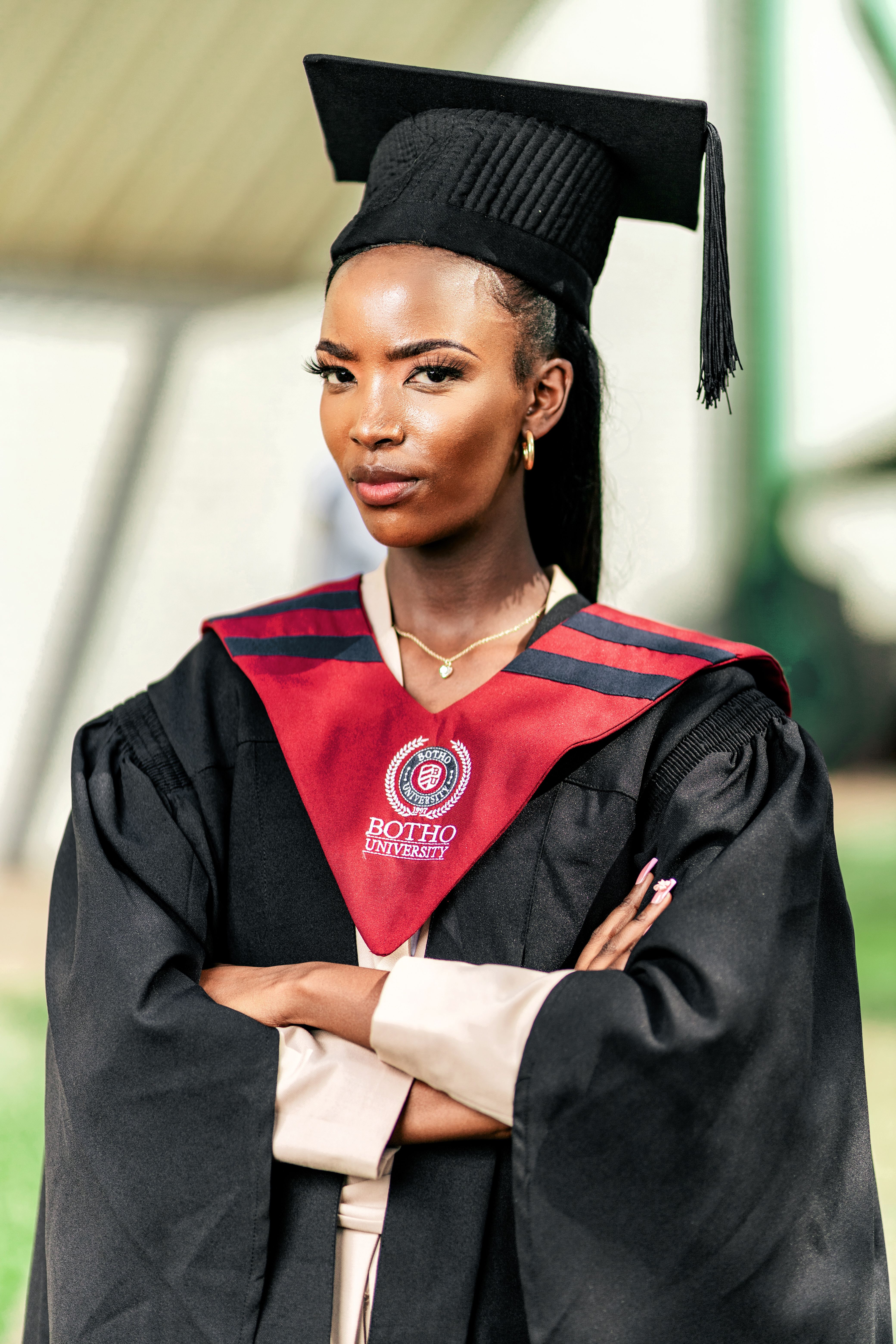 Young woman celebrating graduation with cap and gown outdoors.