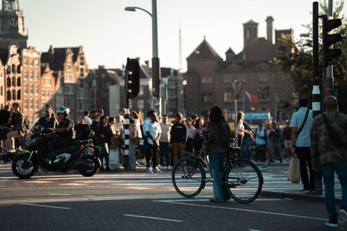 Free Vibrant day in Amsterdam capturing cyclists and pedestrians by historic buildings. Stock Photo
