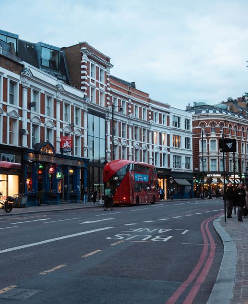 Free A bustling evening street scene in London featuring iconic red double-decker buses and historic architecture. Stock Photo