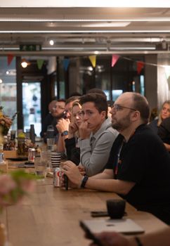 Group of professionals attentively listening during a business meeting in a cozy indoor setting.
