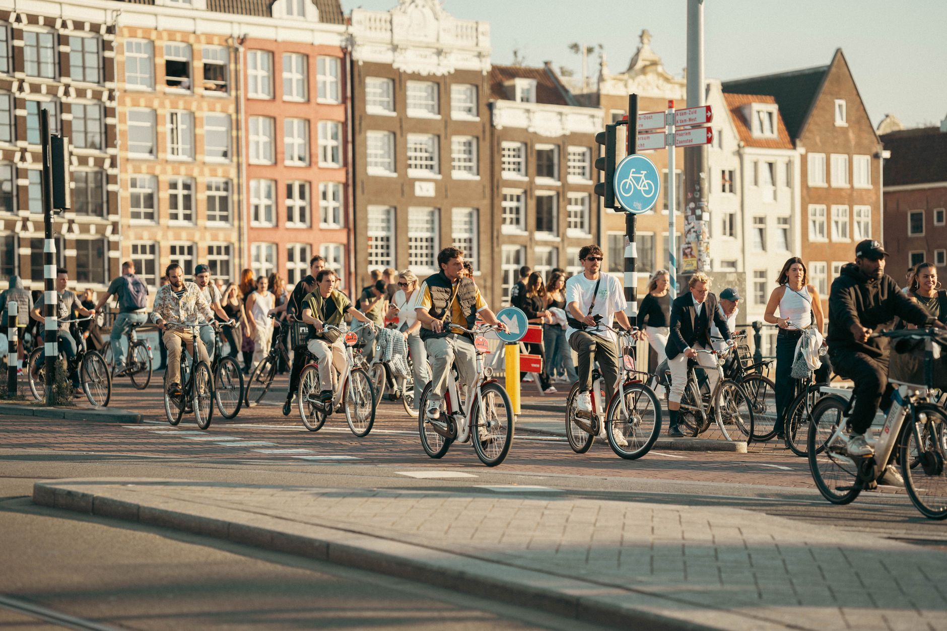 Rotterdam'ın modern caddelerinde, ayrılmış bisiklet yollarında kurallara uygun şekilde bisiklet süren insanlar ve şehir içi trafik düzeni.