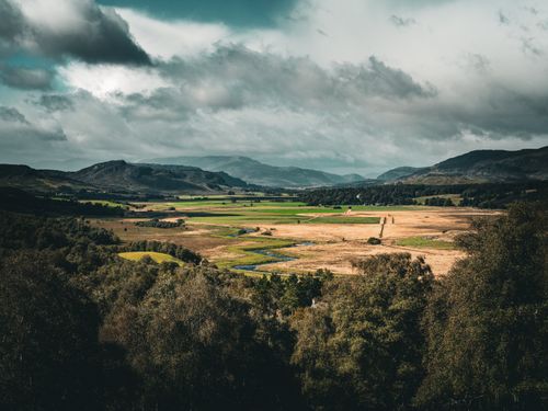 Free Breathtaking view of the Scottish Highlands with dramatic clouds and vast fields. Stock Photo