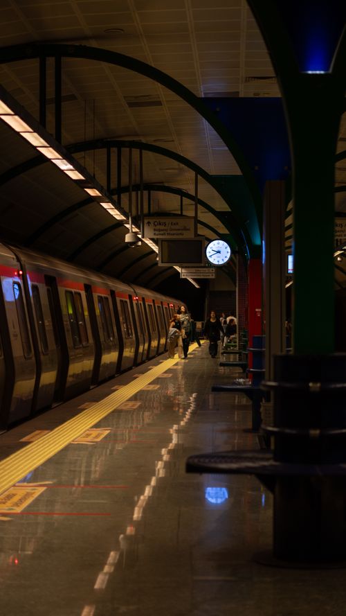 Free Nighttime subway station scene with train and passengers, featuring ambient lighting. Stock Photo