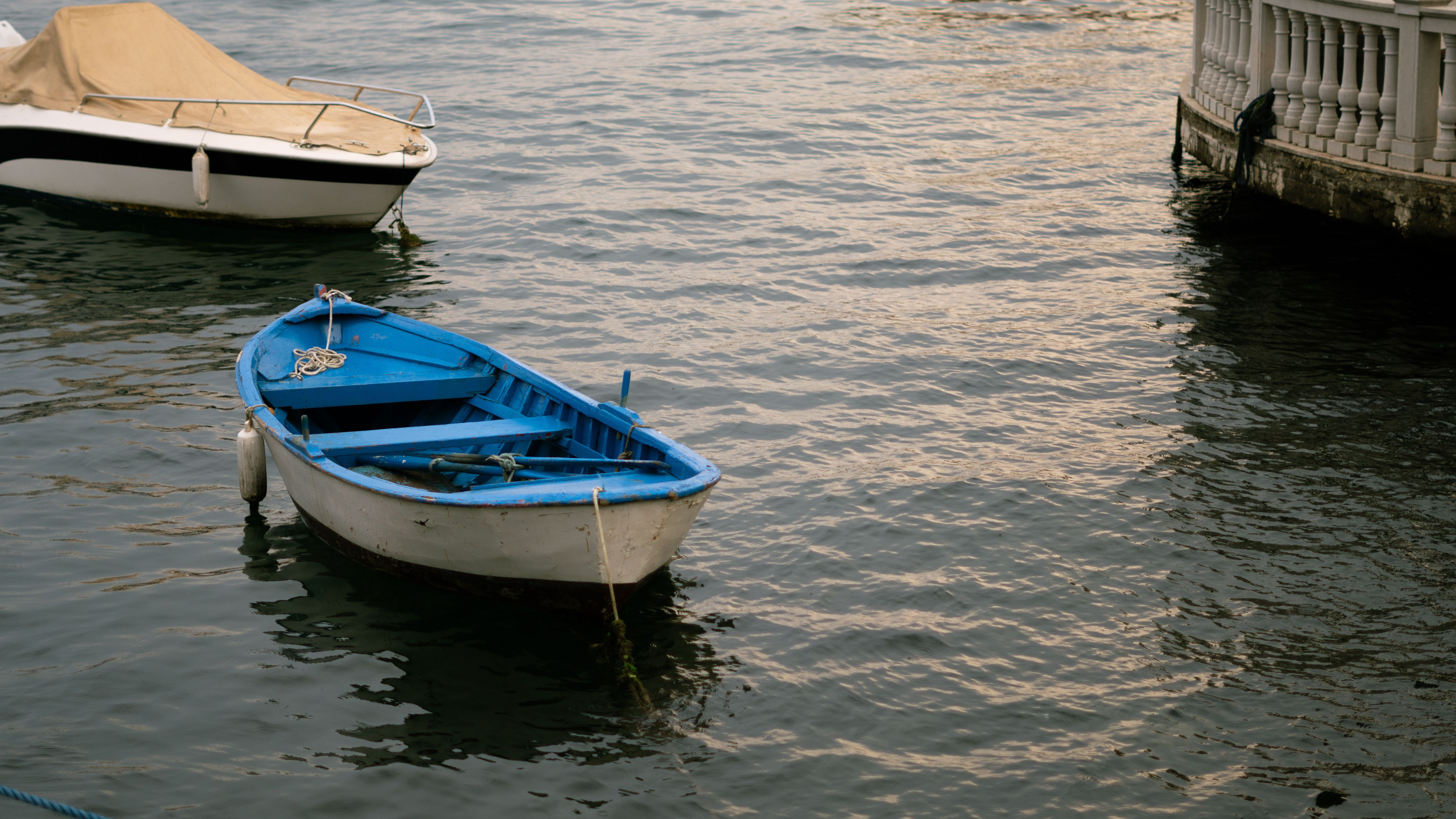 Serene Blue Rowboat Floating on Calm Water · Free Stock Photo