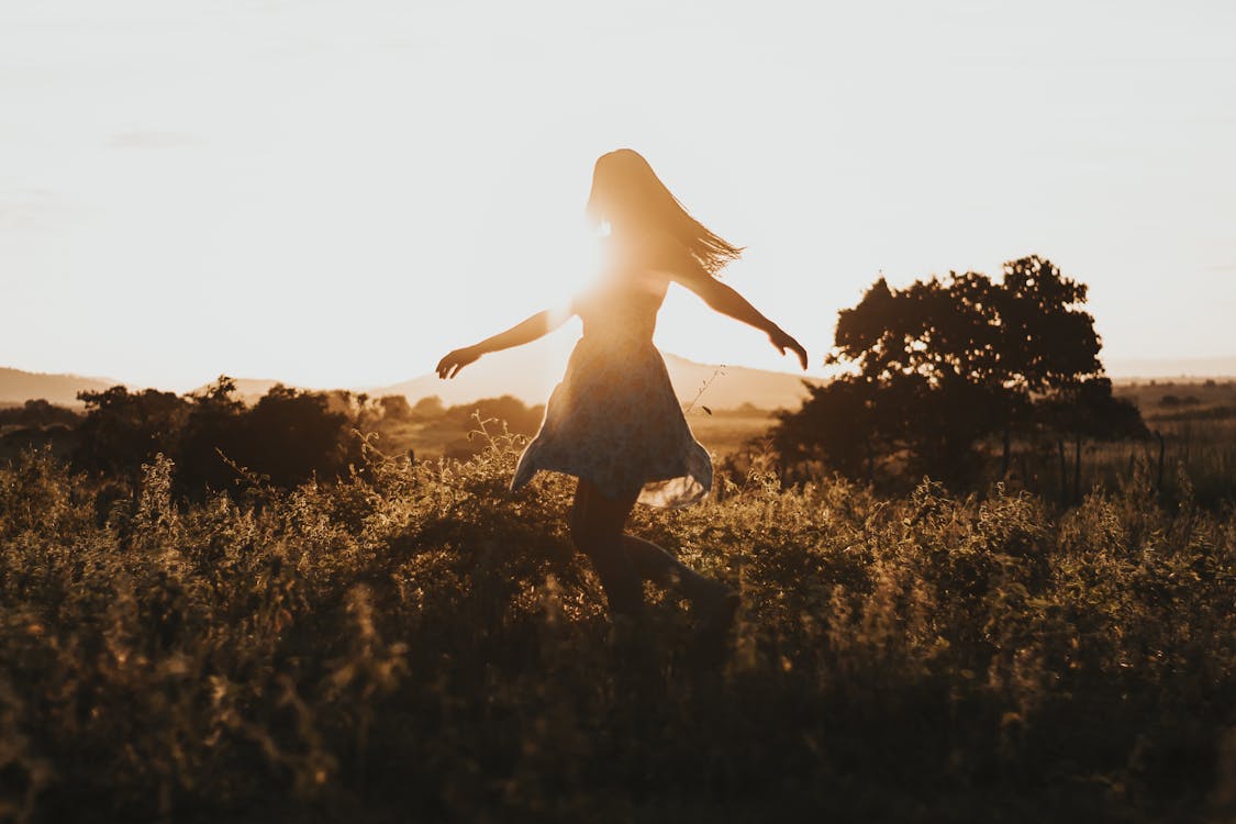 Woman Turning Around on Green Fields