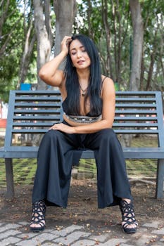 Elegant woman on a bench in a Mexico City park, embracing fashion and tranquility.