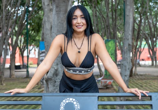 Smiling woman in a park bench at Ciudad de México, showcasing casual fashion.