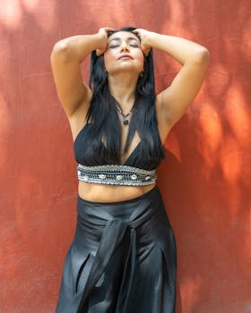 Young woman in Mexico City posing against a textured wall in sunlight.