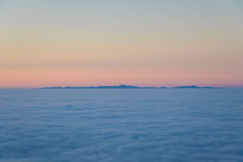 Free Peaceful aerial view of sunrise above clouds in Santa Barbara, capturing pastel sky hues. Stock Photo