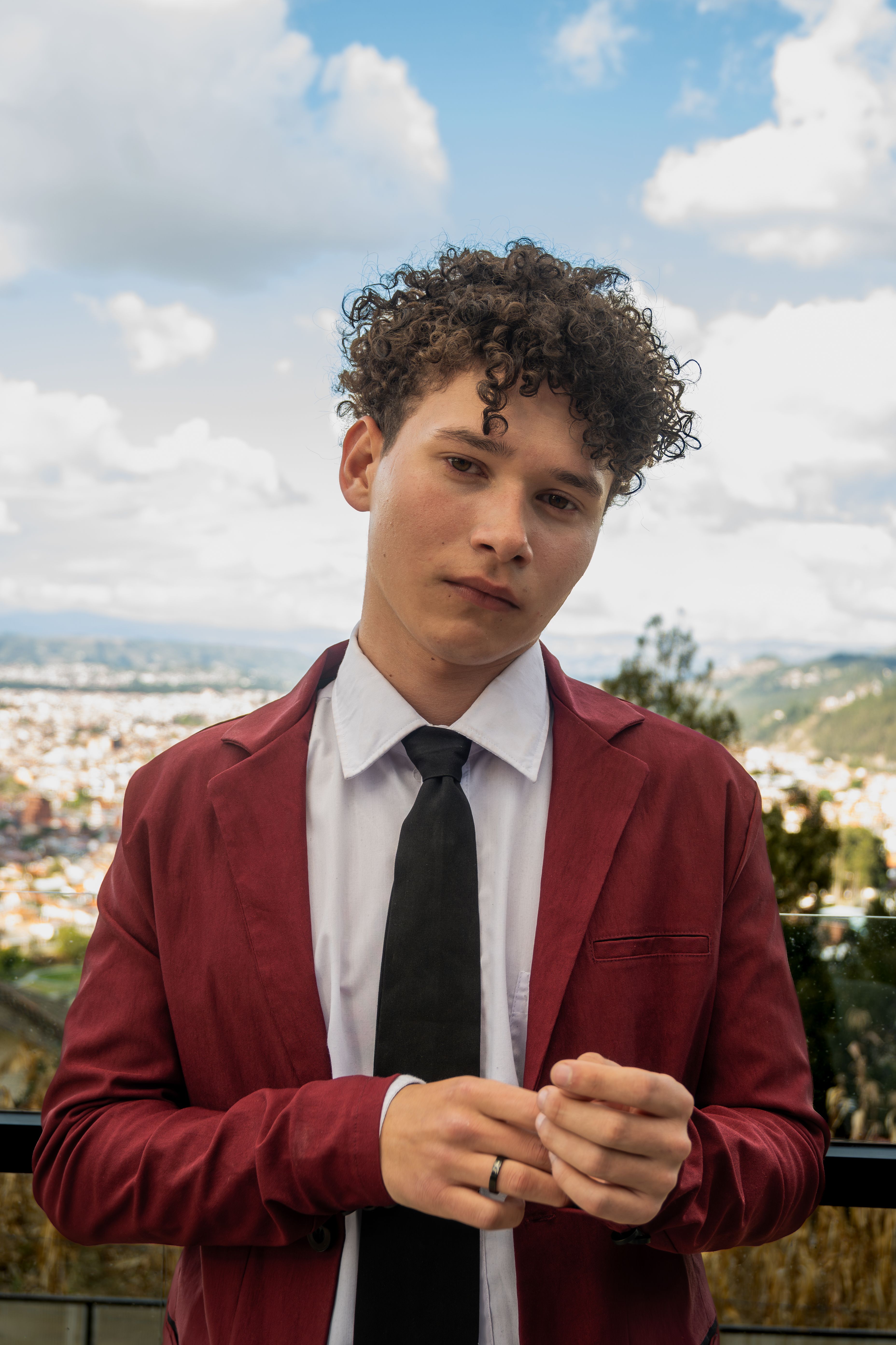Joven Con Chaqueta Roja Posando Al Aire Libre · Foto de stock gratuita