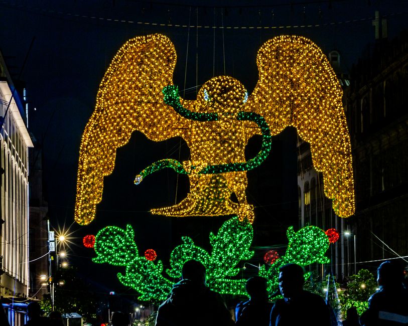 Vibrant night scene featuring an illuminated eagle with a serpent, capturing festive lights in Ciudad de México.