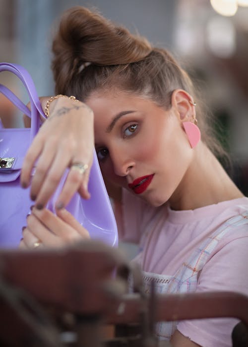 Close-up Photo of Woman in Pink T-shirt Posing By Purple Bag