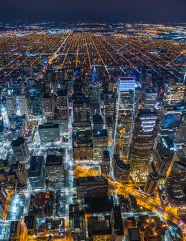Captivating aerial view of a vibrant city illuminated at night, showcasing skyscrapers and streets.