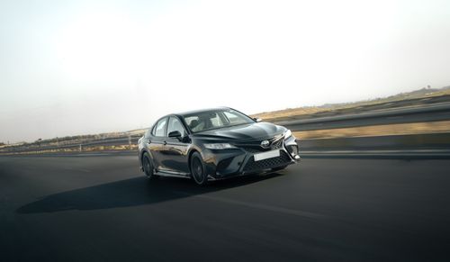 Free A sleek Toyota Camry in motion on a highway, capturing the essence of speed and style. Stock Photo