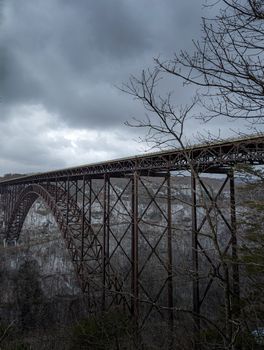 Dramatic winter view of the New River Gorge Bridge with stormy skies.