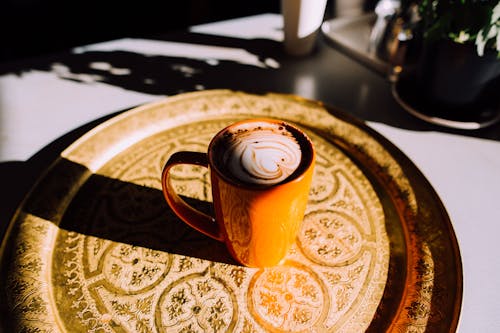 Оранжевая керамическая кружка кофе на подносе