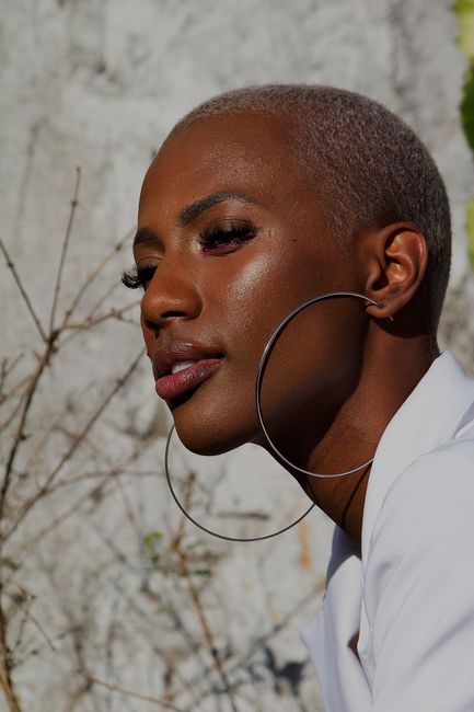Close-up portrait of a woman with short hair and hoop earrings in natural light, RJ, Brazil.