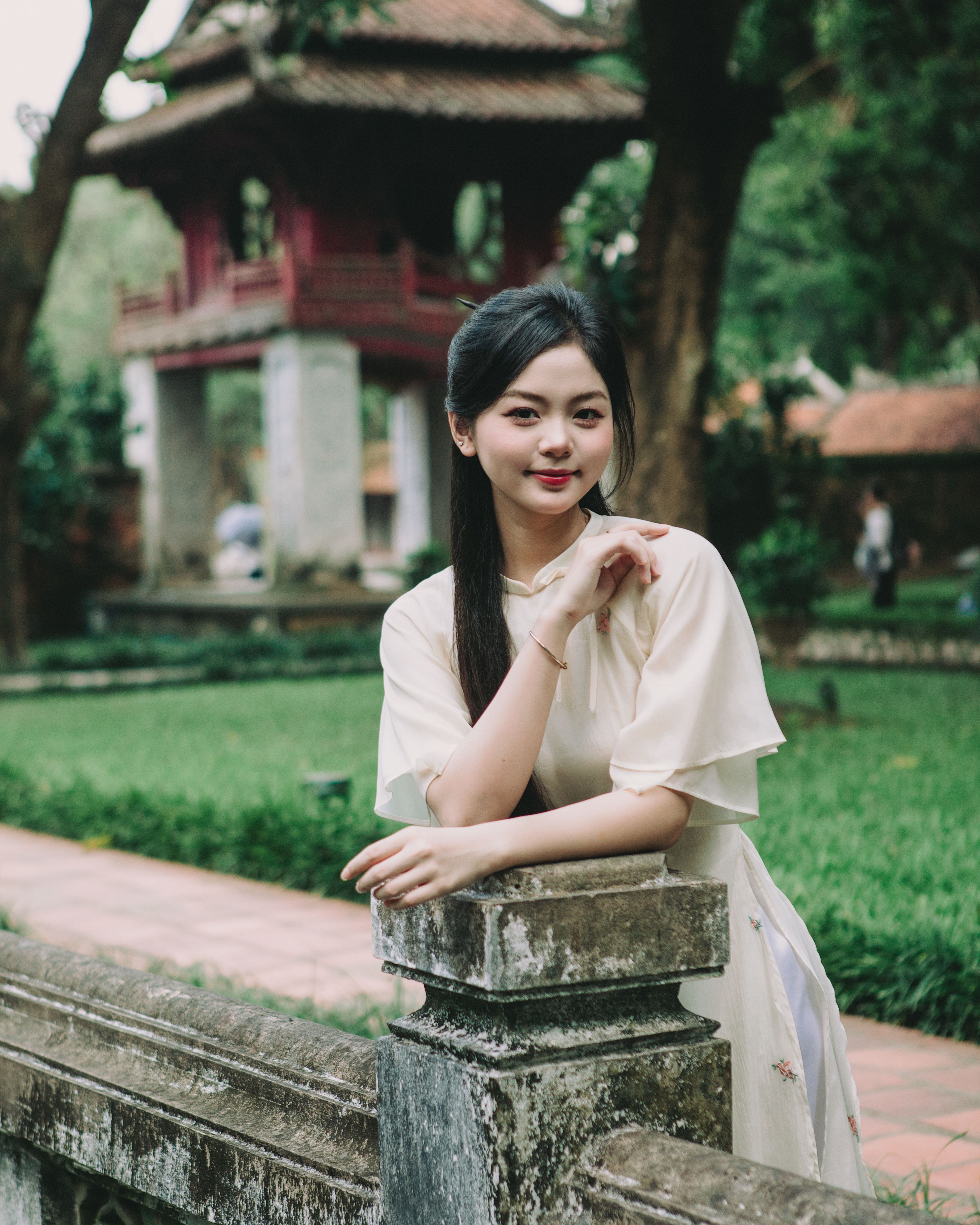 A young woman in an ao dai at the historic Văn Miếu in Hanoi, Vietnam, capturing traditional elegance.