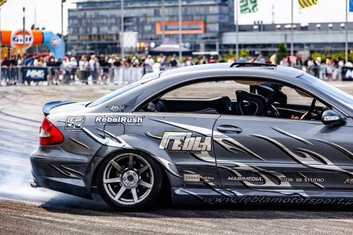 Free Silver sports car drifting at a high-speed motorsport event outdoors. Stock Photo