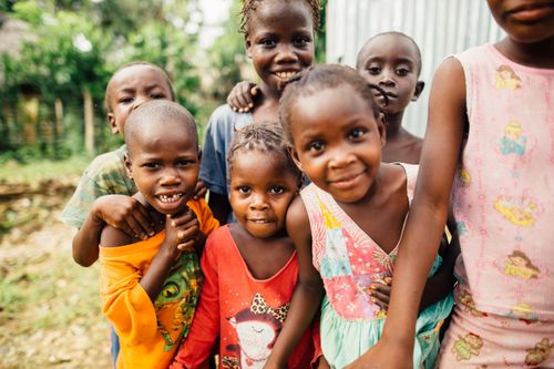 Free A cheerful group of kids smiling and posing together outdoors, full of happiness and energy. Stock Photo