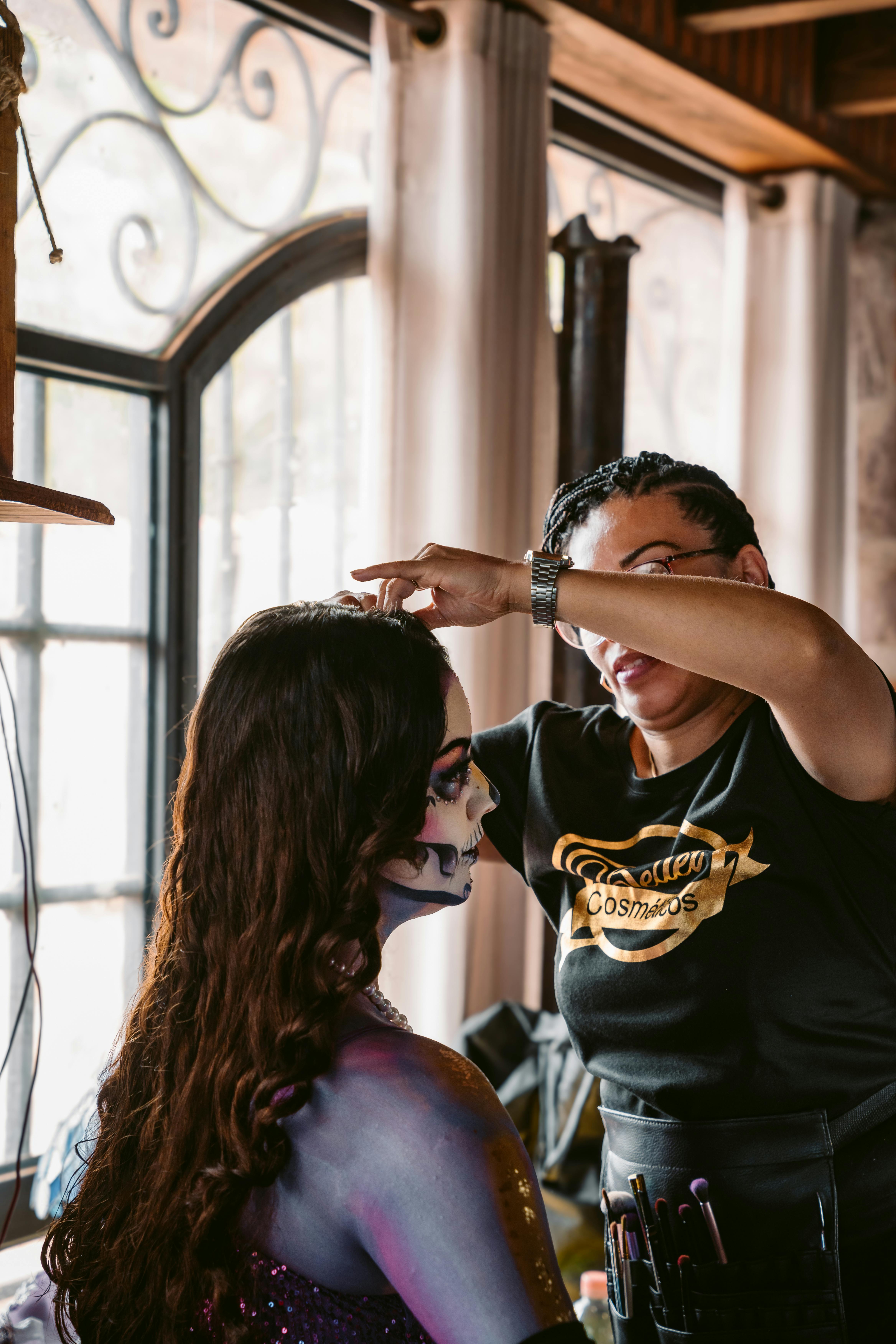 Woman applies vibrant Day of the Dead makeup in Mexican studio.