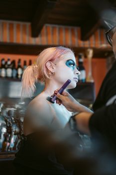 Close-up of a woman getting creative makeup applied indoors in Ciudad de México.