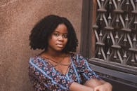 照片拍摄到一名穿着休闲装、留着卷发的女子坐在装饰窗上