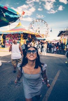 一位女士面带微笑，在摩天轮的背景下享受着热闹的节日